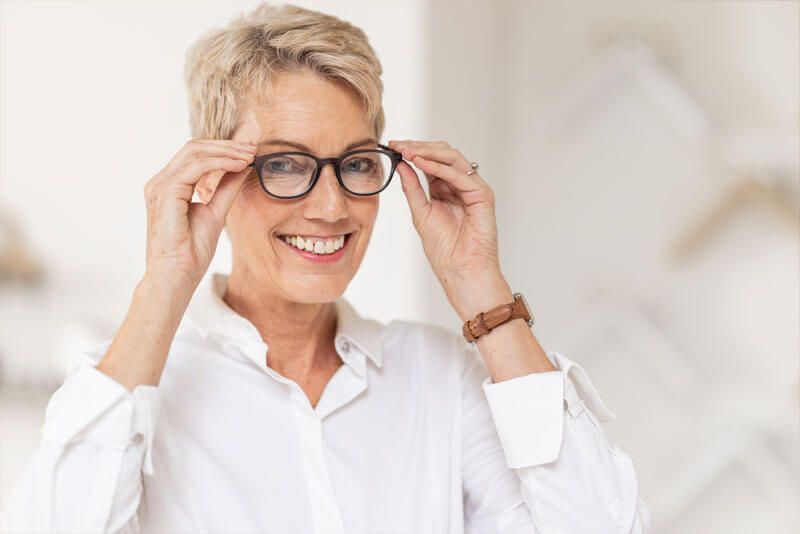 Woman putting on glasses